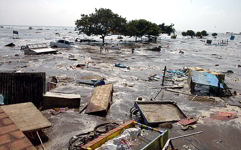 In this photo dated Dec. 26, 2004, water engulfs the entire coastline of Chennai's Marina Beach, sweeping away people, shops, and vehicles after a massive tsunami wave strikes the area.