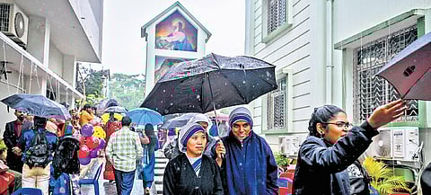 Two Sisters share an umbrella at St Vincent’s Pro-Cathedral Church amid rain in Bhubaneswar on Wednesday