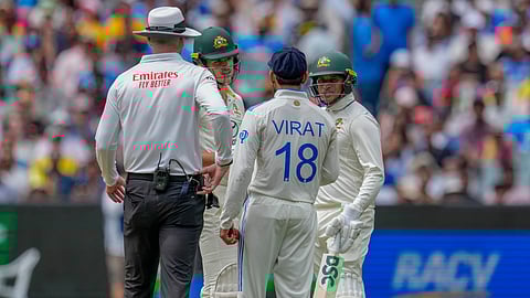 India's Virat Kohli, talks to Australia's Sam Konstas, second left, as Australia's Usman Khawaja, right, looks on during play on the first day of the fourth cricket test between Australia and India.
