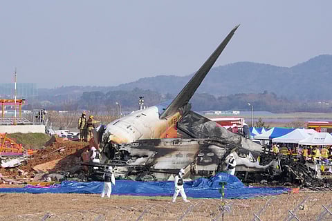 Firefighters and rescue team members work near the wreckage of a passenger plane at Muan International Airport in Muan, South Korea, Sunday, Dec. 29, 2024.