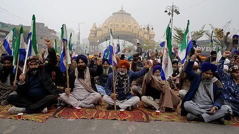 Farmers raise slogans as they block a road during the statewide 'bandh' called as part their ongoing protest, near Golden Gate, in Amritsar, Monday.
