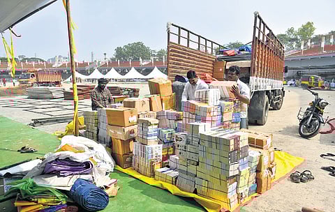 Workers unloading books from a truck at IGMC Stadium on the eve of book festival inauguration in Vijayawada