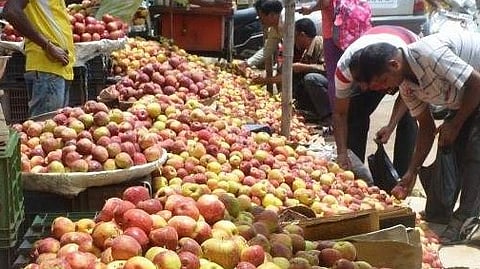 People buying apples from roadside vendors.