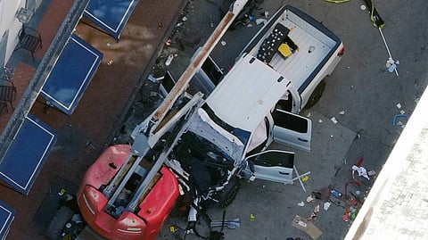 A black flag with white lettering lies on the ground rolled up behind a pickup truck that a man drove into a crowd on Bourbon Street in New Orleans, killing and injuring a number of people, early Wednesday morning.