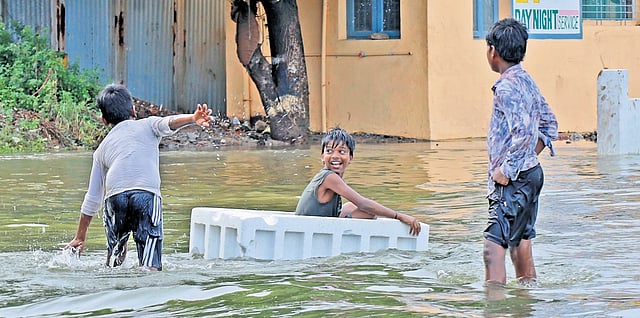 a group of children playing on
a flooded street in Chennai | Express