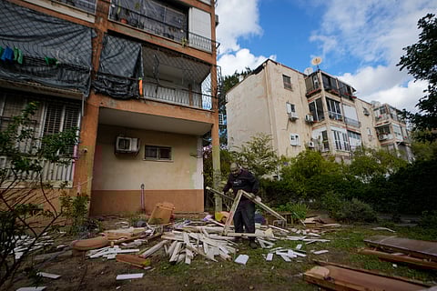 A man works next to damaged building near the site where a missile launched from Yemen landed Jaffa district, in Tel Aviv.