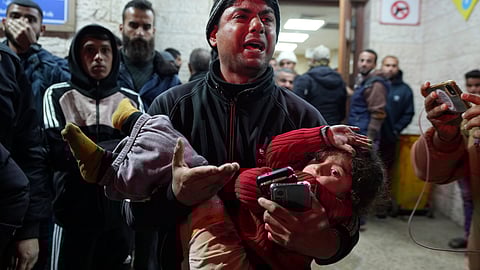 A man reacts while carrying a wounded girl to Al-Aqsa Martyrs Hospital following Israeli army airstrikes in Deir al-Balah, central Gaza Strip, Saturday Jan. 4, 2025.
