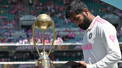 India’s Jasprit Bumrah looks at his Player of the Series award while standing near the Border-Gavaskar Trophy after the fifth and final cricket Test match at the Sydney Cricket Ground on January 5, 2025.
