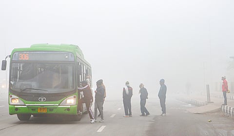 People board a bus during a cold and foggy winter morning, near Akshardham temple, in New Delhi, Saturday, Jan. 4, 2025.