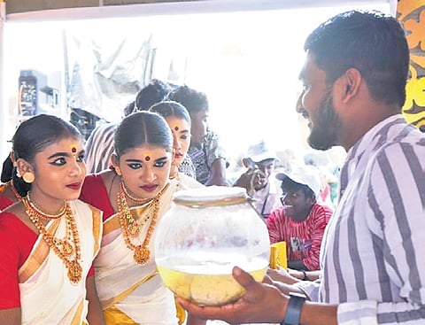 Students in rapt attention to a human brain in a jar at the arts fest venue