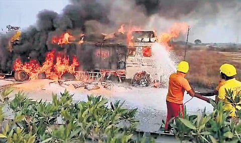 Fire services personnel dousing the burning truck near Jagannathkhunta