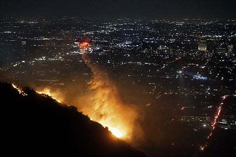 Water is dropped by helicopter on the burning Sunset Fire in the Hollywood Hills section of Los Angeles, Wednesday, Jan 8, 2025.