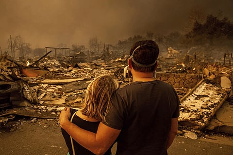 Palisades Fire tears through a Los Angeles neighborhood, fueled by high winds, as thick wildfire smoke engulfs downtown Los Angeles, Wednesday, Jan. 8, 2025.