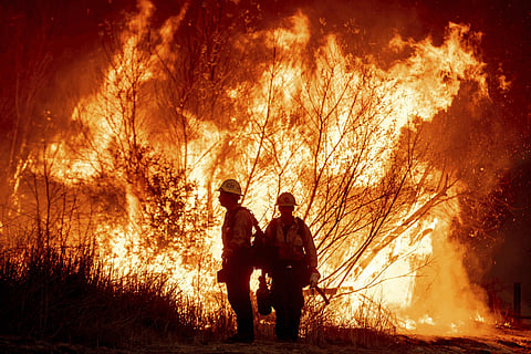 Firefighters battled Thursday to control a series of major fires in the Los Angeles area that have killed seven people and sent thousands of people frantically fleeing their homes.