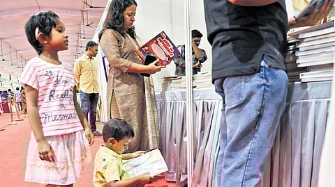 A boy curiously going through a book at the Kerala Legislature International Book Festival-3 venue at the Legislative Assembly complex on Sunday