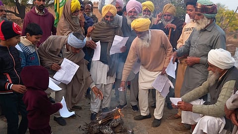 Farmers burning copies of the new farm policy draft.