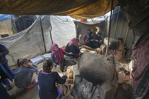 Women make bread at a tent camp for displaced Palestinians in Deir al-Balah, central Gaza Strip, Thursday Jan. 16, 2025.