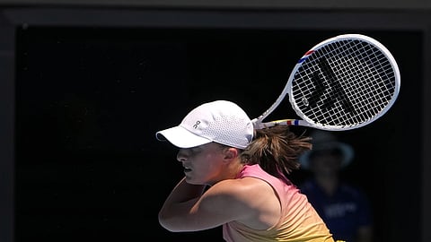 Iga Swiatek of Poland plays a backhand return to Rebecca Sramkova of Slovakia during their second round match at the Australian Open tennis championship in Melbourne, Australia, Thursday, Jan 16, 2025.