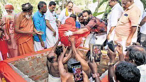The body of Gopan Swami being placed for burial by his children and relatives, near his house at Aralumoodu near Neyyattinkara in Thiruvananthapuram
on Friday.