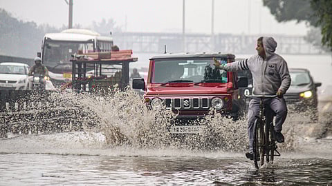 Vehicles move through a waterlogged service road of the Delhi-Gurugram Expressway after heavy rains, in Gurugram, on Thursday.