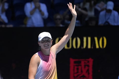 Iga Swiatek of Poland waves after defeating Emma Raducanu of Britain in their third round match at the Australian Open tennis championship in Melbourne, Australia, Saturday, Jan 18, 2025.