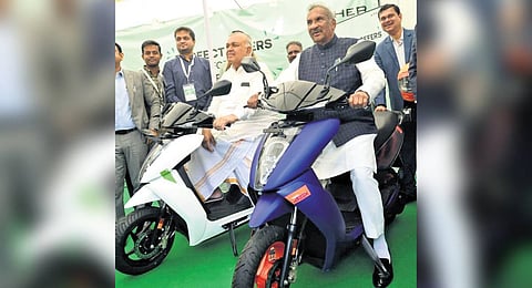 Ministers KJ George and Ramalinga Reddy try their hand at riding an e-bike at Vidhana Soudha on Friday.