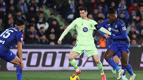 Barcelona's Robert Lewandowski and Getafe's Chrisantus Uche (R) fight for the ball during the Spanish league football match between Getafe CF and FC Barcelona at the Coliseum Alfonso Perez stadium in Getafe on January 18, 2025.