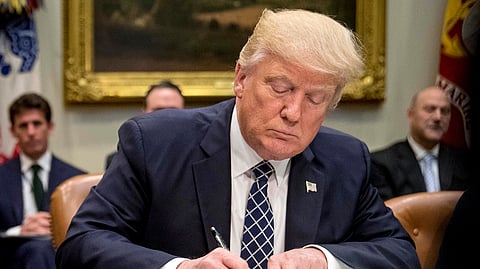 President Donald Trump signs an executive order in the Roosevelt Room of the White House in Washington, April 25, 2017.