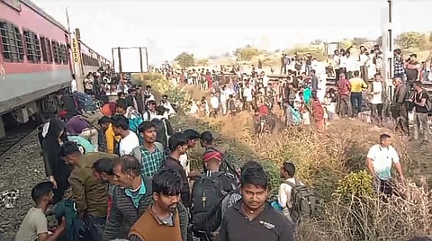 People gather at the site following the death of several passengers after they stepped down due to a rumour of fire and were run over by another train passing on the adjacent tracks, in North Maharashtra's Jalgaon district, Wednesday,