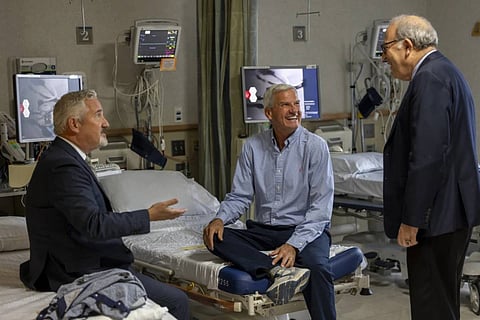 In this photo provided by Massachusetts General Hospital, patient Mike Garrity, centre, is seen speaking with Doctors Joe Garasic, left, and Randy Zusman in Boston, on September 25, 2024.