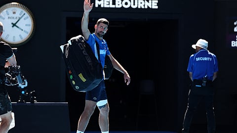 Serbia's Novak Djokovic acknowledges the applause as he exits the court after retiring from the men's singles semifinal against Germany's Alexander Zverev on day thirteen of the Australian Open tennis tournament in Melbourne on January 24, 2025.