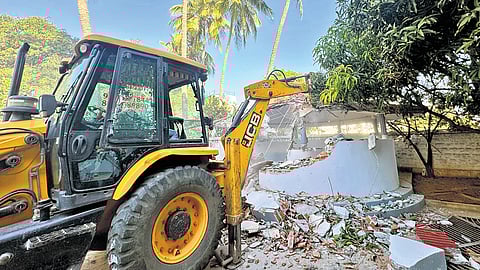 A bulldozer demolishes 4-km compound wall in Pocharam municipality on Saturday