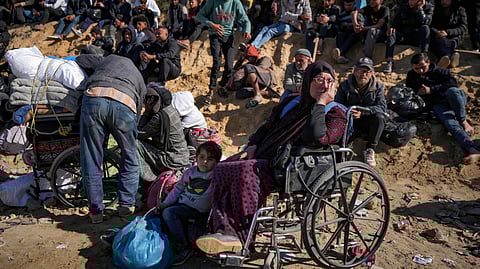 Displaced Palestinians gather with their belongings near a roadblock on the al Rashid Street, as they wait to return to their homes in the northern part of the Gaza Strip, Sunday, Jan. 26, 2025, days after the ceasefire deal between Israel and Hamas came into effect.
