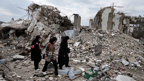 Lebanese citizens pass next to a destroyed house, as they check the destruction in their village caused by the Israeli air and ground offensive, in Aita al-Shaab, a Lebanese border village with Israel, south Lebanon, Sunday, Jan. 26, 2025.