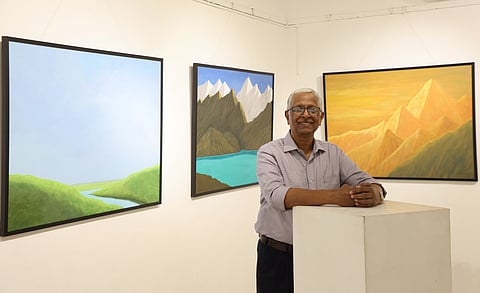 Abraham George poses before his paintings