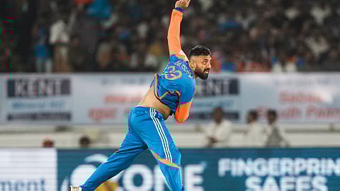 India's Varun Chakravarthy bowls a delivery during the third T20 cricket match between India and England at the Niranjan Shah Stadium in Rajkot, Tuesday, Jan. 28, 2025.