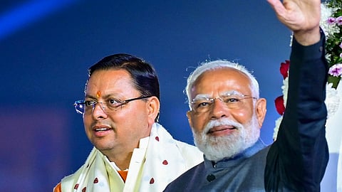Prime Minister Narendra Modi waves at gathering as Uttarakhand CM Pushkar Singh Dhami looks on during the opening ceremony of 38th National Games, in Dehradun, Tuesday, Uttarakhand, Jan. 28, 2025.