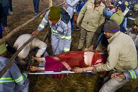 Security personnel rescue a woman during the stampede on 'Mauni Amavasya' at the Maha Kumbh Mela in Prayagraj (Photo | PTI)