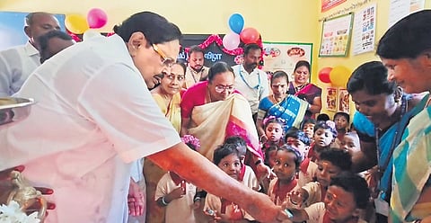 Minister Duraimurugan interacting with children after inaugurating the anganwadi centre at Arumbaruthi village near Katpadi in Vellore on Thursday