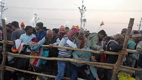 Devotees try to cross a barricade to take a holy dip in the Sangam, the confluence of the Ganges, the Yamuna and the mythical Saraswati rivers, on "Mauni Amavasya" or new moon day during the Maha Kumbh festival in Prayagraj, India, Wednesday, Jan. 29, 2025.