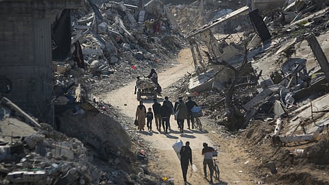 Palestinians who have returned walk among the rubble of buildings largely destroyed by Israeli army bombardments in Beit Lahia, northern Gaza Strip, Wednesday, Jan. 29, 2025.