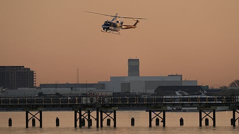 A US Park Police helicopter flies over the Potomac River near Ronald Reagan Washington National Airport, Thursday, Jan. 30, 2025