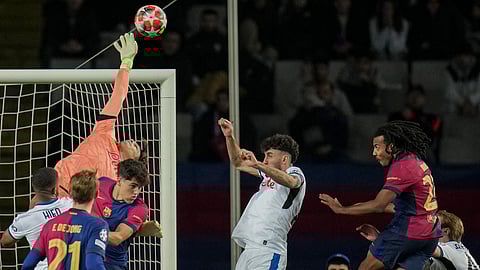 Atalanta's goalkeeper Marco Carnesecchi, top left, makes a save during a Champions League opening phase soccer between Barcelona and Atalanta match at the Lluis Companys Olympic stadium in Barcelona, Spain, Wednesday, Jan. 29, 2025.