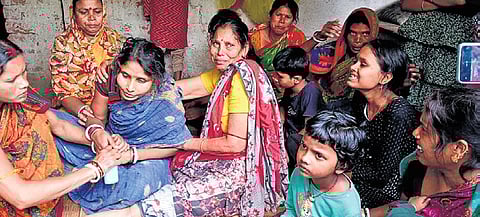 Villagers consoling Jena’s wife Mily after the mishap on Saturday.