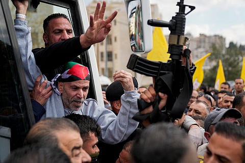 Palestinian prisoners are greeted as they exit a Red Cross bus after being released from Israeli prison following a ceasefire agreement between Israel and Hamas, in the West Bank city of Ramallah, Saturday Feb. 1, 2025.