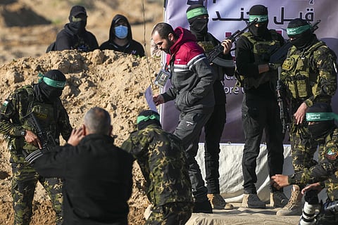 Israeli Yarden Bibas, 34, who has been held hostage by Hamas in Gaza since Oct 7, 2023, is escorted by Hamas fighters before being handed over to the Red Cross in Khan Younis