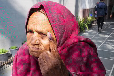 An elderly voter shows her finger marked with indelible ink after casting vote during the Delhi Assembly elections (Photo | PTI)