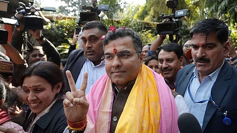 New Delhi constituency winning candidate Parvez Verma shows victory sign at his residence in New Delhi on Saturday.
