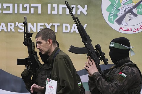 Israeli captive Or Levy, who has held hostage by Hamas in Gaza since October 7, 2023, is escorted by Hamas fighters before being handed over to the Red Cross in Deir al-Balah, central Gaza Strip, Saturay, Feb 8, 2025