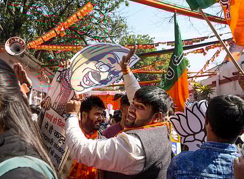 New Delhi: BJP supporters beat a cut-out of AAP leader Arvind Kejriwal as they celebrate the party's decisive lead in the Delhi Assembly polls as counting of votes is underway, outside the Delhi BJP office in New Delhi, Saturday, Feb. 8, 2025